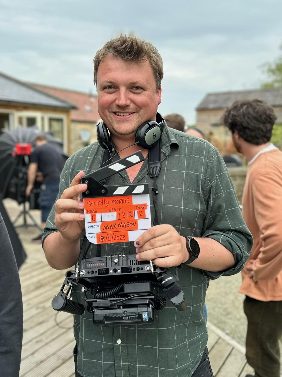 Max Mason on set with a clapperboard